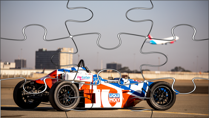 Puzzle pieces of orange, blue and white race car