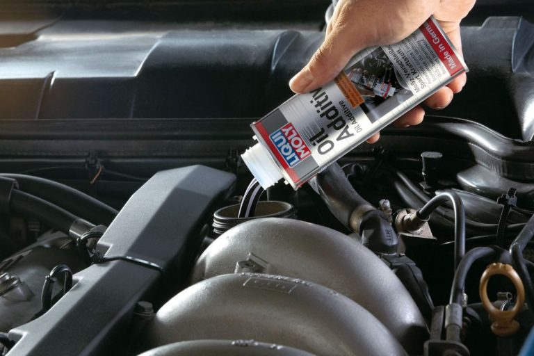 Man pouring Liqui Moly oil additive in car engine